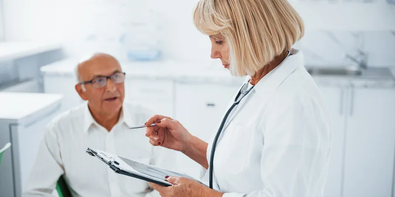KI-Telefonassistent für Arztpraxen: Ärztin bespricht Unterlagen mit einem Patienten
