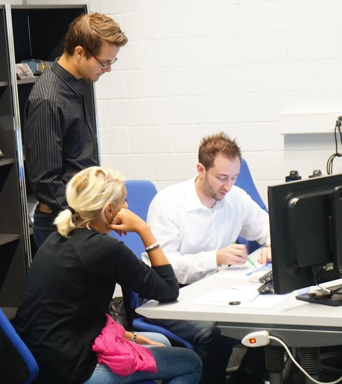 Michael Kälin in der Projektarbeit an der Logistiksoftware mit Teamkollegen am Bildschirm
